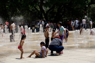 18 Haziran 2023, Mexico City, Meksika: Meksika 'daki Meksika Devrimi Anıtı' ndaki dans çeşmelerinde serinleyen insanlar, sıcaklığı 31 ila 33 derece arasında değişen üçüncü sıcak hava dalgası nedeniyle Orange Alert 'ın etkinleştirilmesi nedeniyle