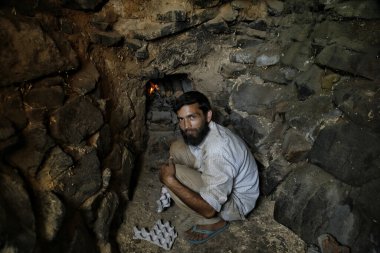 10 Ağustos 2023, Srinagar Kashmir, Hindistan: Bir Keşmir çömlekçisi olan Mohiuddin Kumar, Srinagar 'ın eteklerinde fırın hazırlıyor. Kaşmir düğünlerinde geleneksel müziğin kültürel önemi büyüktür.