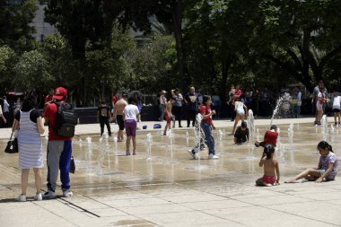 18 Haziran 2023, Mexico City, Meksika: Meksika 'daki Meksika Devrimi Anıtı' ndaki dans çeşmelerinde serinleyen insanlar, sıcaklığı 31 ila 33 derece arasında değişen üçüncü sıcak hava dalgası nedeniyle Orange Alert 'ın etkinleştirilmesi nedeniyle