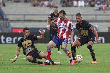 10 Nisan 2023, Mexico City, Jesus Molina ve Nicols Freire of Pumas San Luis futbol kulübünden Leonardo Bonatini ile Clausura 2023 'teki Club Universidad Nacional arasındaki maç sırasında karşı karşıya geldiler.