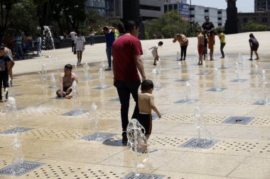 18 Haziran 2023, Mexico City, Meksika: Meksika 'daki Meksika Devrimi Anıtı' ndaki dans çeşmelerinde serinleyen insanlar, sıcaklığı 31 ila 33 derece arasında değişen üçüncü sıcak hava dalgası nedeniyle Orange Alert 'ın etkinleştirilmesi nedeniyle