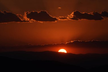 Güneş, Tepoztlan 'ın dağlık bölgesindeki manzaranın tadını çıkarmak için kış günbatımında dağların arkasında batar..