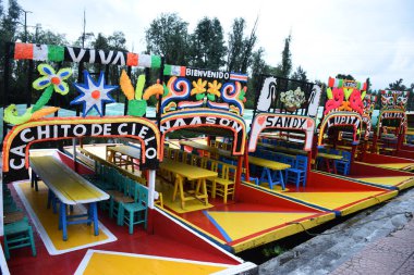 Meksika 'nın en temsilci yerlerinden biri olan turistleri turist turnesine çıkarmak için kullanılan Xchimilco iskelesindeki Trajineras teknesinin genel manzarası..