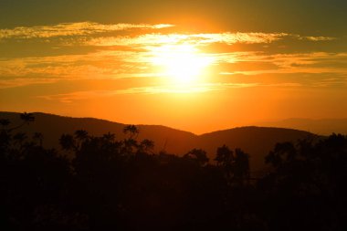 Güneş, Tepoztlan 'ın dağlık bölgesindeki manzaranın tadını çıkarmak için kış günbatımında dağların arkasında batar..