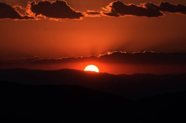 Güneş, Tepoztlan 'ın dağlık bölgesindeki manzaranın tadını çıkarmak için kış günbatımında dağların arkasında batar..