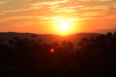 Güneş, Tepoztlan 'ın dağlık bölgesindeki manzaranın tadını çıkarmak için kış günbatımında dağların arkasında batar..