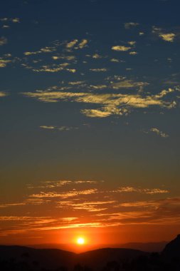 Güneş, Tepoztlan 'ın dağlık bölgesindeki manzaranın tadını çıkarmak için kış günbatımında dağların arkasında batar..