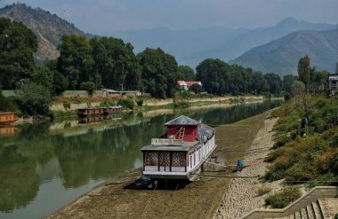 Srinagar, Kashmir, Hindistan - 12 Eylül 2023: Srinagar 'da devam eden kurak dönem nedeniyle, ev sahipleri nehir tabanındaki ahşap kütükleri sabitlediler.