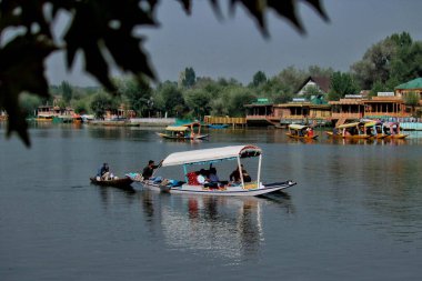Srinagar Kashmir, Hindistan - 27 Eylül 2023: Turistler, Srinagar 'da düzenlenen Dünya Turizm Günü münasebetiyle Dal Gölü' nün sularında tekne turunun keyfini çıkarıyorlar. Turizm, tarım dışında Kaşmir ekonomisinin ana merkezlerinden biridir.