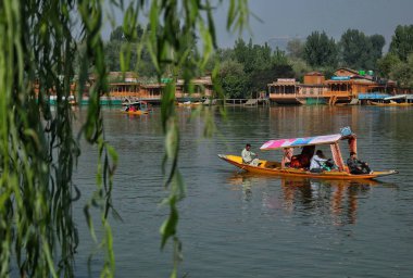 Srinagar Kashmir, Hindistan - 27 Eylül 2023: Turistler, Srinagar 'da düzenlenen Dünya Turizm Günü münasebetiyle Dal Gölü' nün sularında tekne turunun keyfini çıkarıyorlar. Turizm, tarım dışında Kaşmir ekonomisinin ana merkezlerinden biridir.