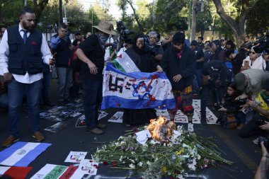 12 Ekim 2023, Mexico City, Meksika: İsrail 'in Meksika Büyükelçiliği önünde İsrail ordusunun Filistin halkına karşı düzenlediği saldırıları protesto etmek ve Gazze' ye karşı savaşın durdurulması talebiyle bir kadın İsrail bayrağını yaktı.