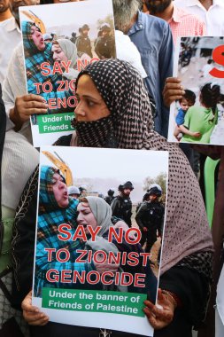 13 Ekim 2023, Kolkata Şehri, Hindistan: Hintli Müslüman kadınlar İsrail 'e karşı düzenlenen bir protesto sırasında çeşitli mesajlar içeren bir pankart tutuyorlar ve Gazze' deki savaşın durdurulmasını talep ediyorlar.