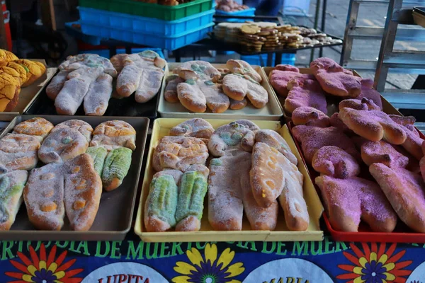 Meksika, Nezahualcyotl 'da 27 Ekim 2023: Satıcılar Pan de Muerto Fuarı sırasında susamlı, şekerli, geleneksel ve farklı dolgularla farklı türde ölü, zanaatkar ekmek sunuyorlar.