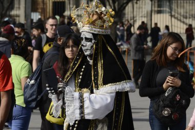 1 Kasım 2023, Mexico City, Mexico: Ölüm Günü münasebetiyle tanımlanan bir kişi Mexico City Zocalo 'da Ölüm Günü' nün Mega Monumental Teklifi sırasında kartondan yapılmış muazzam bir kafatasının fotoğrafını çeker.