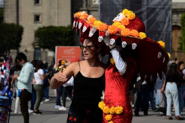 1 Kasım 2023, Mexico City: Bir kadın Mexico City Zocalo 'da Mega Monumental Day of the Dead' de Catrina ile fotoğraf çektirmek için poz veriyor.