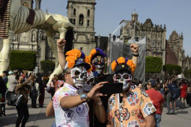 1 Kasım 2023 'te Mexico City, Meksika' da Mexico City 'deki Mega Monumental Sunumu sırasında maskeli turistler selfie çektiler.