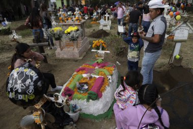 2 Kasım 2023, Mexico City, Mexico: Akrabalar, San Antonio Tecomitl Panteonu 'nda, Mexico City' deki Milpa Alta Belediye Başkanı 'nın ofisinde, Ölüler Günü sırasında sevdiklerinin mezarlarını çamur heykellerle süslerler.