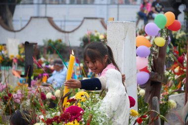 2 Kasım 2023, Mexico City, Meksika: Akrabalar, Ölüler Günü kutlamaları sırasında mezarları cempasuchil çiçekleriyle süsler ve sevdiklerinin mezarlarını mumlarla aydınlatır, panteonu renk ve folklorla doldururlar.