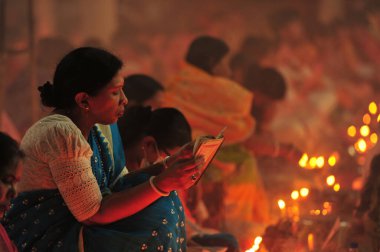 04 Kasım 2023 Sylhet-Bangladeş: Bangladeş 'in Sylhet kentindeki Loknath Tapınağı' ndaki Rakher Upobash festivalini izlemek için bir tapınağın zemininde birlikte oturuyorlar