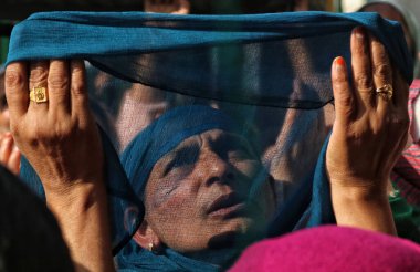 03.2023 Kasım 'ında Hindistan' ın Srinagar Kashmir kenti: Müslüman dindarlar, bir rahibin 'urs' veya yaklaşık 1000 yıl önce Bağdat 'ta yaşamış olan Sufi azizinin ölüm yıldönümünü simgeleyen bir kutsal emaneti sergilemesi için dua ediyorlar.