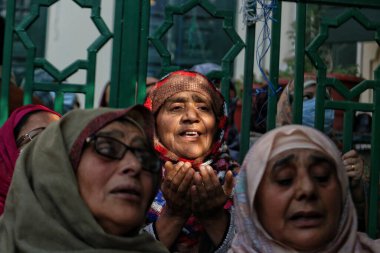 03.2023 Kasım 'ında Hindistan' ın Srinagar Kashmir kenti: Müslüman dindarlar, bir rahibin 'urs' veya yaklaşık 1000 yıl önce Bağdat 'ta yaşamış olan Sufi azizinin ölüm yıldönümünü simgeleyen bir kutsal emaneti sergilemesi için dua ediyorlar.