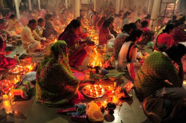 04 Kasım 2023 Sylhet-Bangladeş: Bangladeş 'in Sylhet kentindeki Loknath Tapınağı' ndaki Rakher Upobash festivalini izlemek için bir tapınağın zemininde birlikte oturuyorlar