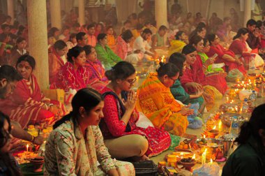 04 Kasım 2023 Sylhet-Bangladeş: Bangladeş 'in Sylhet kentindeki Loknath Tapınağı' ndaki Rakher Upobash festivalini izlemek için bir tapınağın zemininde birlikte oturuyorlar