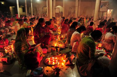 04 Kasım 2023 Sylhet-Bangladeş: Bangladeş 'in Sylhet kentindeki Loknath Tapınağı' ndaki Rakher Upobash festivalini izlemek için bir tapınağın zemininde birlikte oturuyorlar