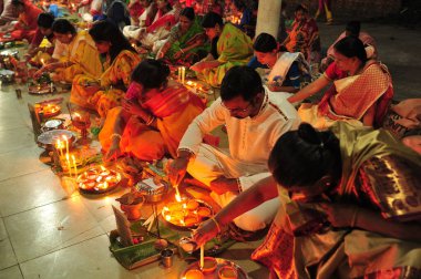 07 Kasım 2023 Sylhet-Bangladeş: Hindu dindarlar Sylhet, Bangladeş 'teki Loknath Tapınağı' ndaki Rakher Upobash festivalini izlemek için bir tapınağın zemininde birlikte oturuyorlar. Lokenath Brahmachari, Baba Lokenath 18. yüzyılda yaşamış bir Hindu 'ydu.