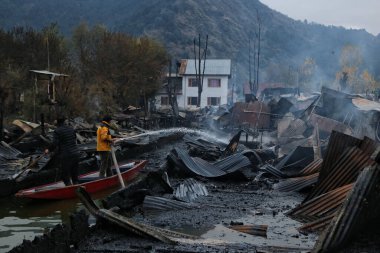 11 Kasım 2023, Srinagar Kashmir, Hindistan: Kaşmirli bir adam Srinagar 'daki Dal Gölü' nde çok sayıda yüzen evi yakan yangını söndürmek için çalışıyor