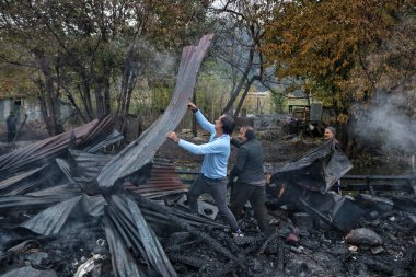 11 Kasım 2023, Srinagar Kashmir, Hindistan: İnsanlar Srinagar 'daki Dal Gölü' nde meydana gelen yangın sonrasında enkazdan kendilerine ait eşyaları arıyorlar. Srinagar 'daki Dal Gölü' nün merkezindeki yüzen evlerde büyük bir yangın patlak verdi.