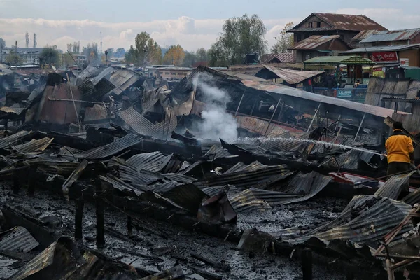 11 Kasım 2023, Srinagar Kashmir, Hindistan: Kaşmirli bir adam Srinagar 'daki Dal Gölü' nde çok sayıda yüzen evi yakan yangını söndürmek için çalışıyor.