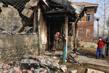 17 Kasım 2023, Srinagar Kashmir, Hindistan: Güney Kashmirs Kulgam 'da beş militanın öldürüldüğü Srinagar' a yaklaşık 80 kilometre mesafede meydana gelen silahlı çatışmada hasar görmüş bir evin önünde bir Kaşmir kadını yürüyor