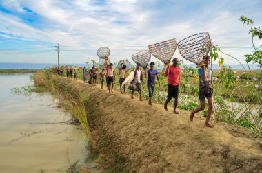 28 Kasım 2023 Sylhet-Bangladeş: Bambu balık tuzakları ve Net ile donatılmış kırsal insanlar, Sylhet 'in Kanaighat upazila birliğinin jofra beel' inde 200 yıllık bir kış balıkçılık festivalinde yer alıyorlar.