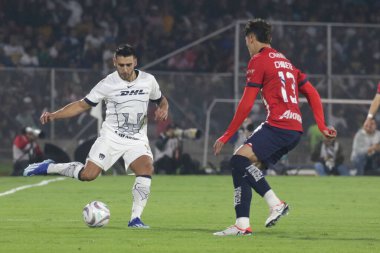 3 Aralık 2023, Mexico City, Meksika UNAM Pumas takımından Eduardo Salvio, MX Ligi 'nin çeyrek finallerinin ikinci ayağı boyunca Guadalajara Chivas takımından Jess Orozco' ya karşı mücadele etti.