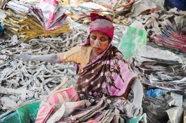 10 Aralık 2023 Sylhet-Bangladeş: Bangladeş 'in Sylhet kentindeki Surma Nehri' nin yanındaki çimento torbalarını yıkamak için kadın işçiler hayatlarını tehlikeye atıyor. Dahası, uzun vadeli sağlıklarına zarar verdiği için, plastik tozlar nehir yatağını da dolduruyor.