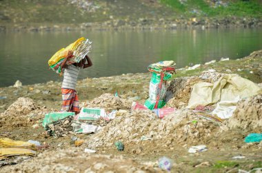 10 Aralık 2023 Sylhet-Bangladeş: İşçiler, Sylhet, Bangladeş 'teki Surma Nehri' nin sularında çimento torbaları yıkamak için hayatlarını tehlikeye atıyorlar. Dahası, uzun vadeli sağlıklarına da zarar veriyor.
