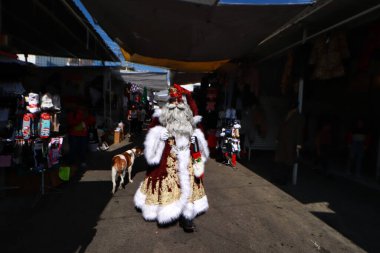 9 Aralık 2023 'te Mexico City, Meksika' da Miguel Moctezuma heykeltraşlık ve makyaj konusunda uzmanlaşmış Cuauhtmoc belediye başkanının ofisinde Tepito sokaklarında turlamak için kendini Noel Baba olarak tanımlıyor.