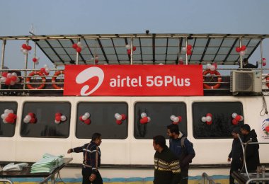 12 Aralık 2023, Srinagar Kashmir, Hindistan: İnsanlar 5G Plus 'ın logosunun önünden geçerken Srinagar' daki 5G + deneyimi sırasında görüldü. Airtel, 5G hizmetlerinin başlatıldığını duyurdu.