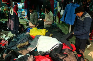 13 Aralık 2023, Srinagar Kashmir, Hindistan: İnsanlar Srinagar 'daki bir pazardan kış başlıkları ve diğer eşyalar satın alıyorlar. Kışın gelmesiyle birlikte sıradan Kaşmirliler sert havaya hazırlanmaya, kazak, ceket ve diğer kalın giysiler almaya başladılar.