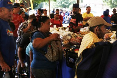 18 Aralık 2023, San Francisco, Venezuela: Venezuelalılar, temel sepetten 300 ton yiyecek satarak binlerce aileye fayda sağlamak amacıyla bu pazartesi Halk Pazarı yardım programı sırasında yiyecek almak için sıraya girdiler.