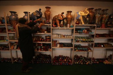16 Aralık 2023, Srinagar Kashmir, Hindistan: Bir Kaşmir sanatçısı, Srinagar 'daki Noel kutlamaları öncesinde onları pazara göndermeden önce atölyedeki kağıt mache mücevherlerinden yapılmış hediye eşyalar düzenliyor