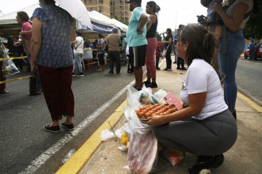 18 Aralık 2023, San Francisco, Venezuela: Venezuelalılar, temel sepetten 300 ton yiyecek satarak binlerce aileye fayda sağlamak amacıyla bu pazartesi Halk Pazarı yardım programı sırasında yiyecek almak için sıraya girdiler.