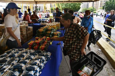 18 Aralık 2023, San Francisco, Venezuela: Venezuelalılar, temel sepetten 300 ton yiyecek satarak binlerce aileye fayda sağlamak amacıyla bu pazartesi Halk Pazarı yardım programı sırasında yiyecek almak için sıraya girdiler.