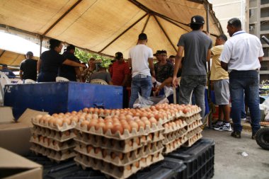 18 Aralık 2023, San Francisco, Venezuela: Venezuelalılar, temel sepetten 300 ton yiyecek satarak binlerce aileye fayda sağlamak amacıyla bu pazartesi Halk Pazarı yardım programı sırasında yiyecek almak için sıraya girdiler.