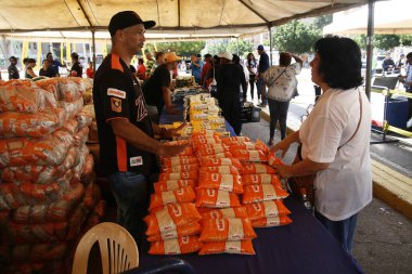 18 Aralık 2023, San Francisco, Venezuela: Venezuelalılar, temel sepetten 300 ton yiyecek satarak binlerce aileye fayda sağlamak amacıyla bu pazartesi Halk Pazarı yardım programı sırasında yiyecek almak için sıraya girdiler.