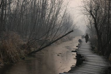21 Aralık 2023, Srinagar Kashmir, Hindistan: Soğuk bir kış sabahı Srinagar 'da buzla kaplı ahşap bir köprüde yürüyen bir adam. En sert 40 günlük kış dönemi olan Chillai-Kalan, Perşembe günü Kaşmir 'de başlıyor.