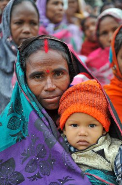 17 Ocak 2024 Sylhet-Bangladeş: Soğuk bir sabah Tarapur Çay Bahçesi 'nde gardiyanın kucağında bir çocuk. Sylhet 'te kış mevsiminin şiddetinin artması nedeniyle çocuklar ve yaşlılar acı çekiyor. 