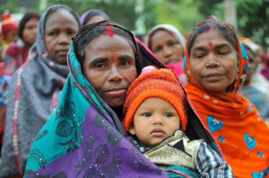 17 Ocak 2024 Sylhet-Bangladeş: Soğuk bir sabah Tarapur Çay Bahçesi 'nde gardiyanın kucağında bir çocuk. Sylhet 'te kış mevsiminin şiddetinin artması nedeniyle çocuklar ve yaşlılar acı çekiyor. 