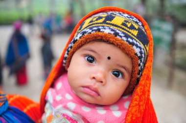 17 Ocak 2024 Sylhet-Bangladeş: Soğuk bir sabah Tarapur Çay Bahçesi 'nde gardiyanın kucağında bir çocuk. Sylhet 'te kış mevsiminin şiddetinin artması nedeniyle çocuklar ve yaşlılar acı çekiyor.